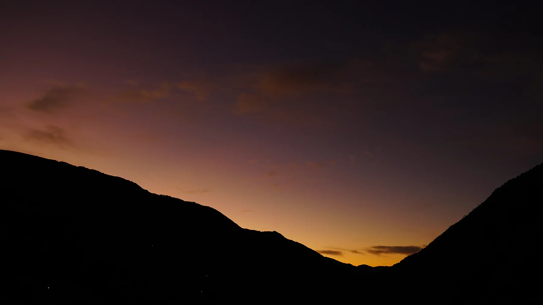 Pre-sunrise colours between the dark mountain ridges