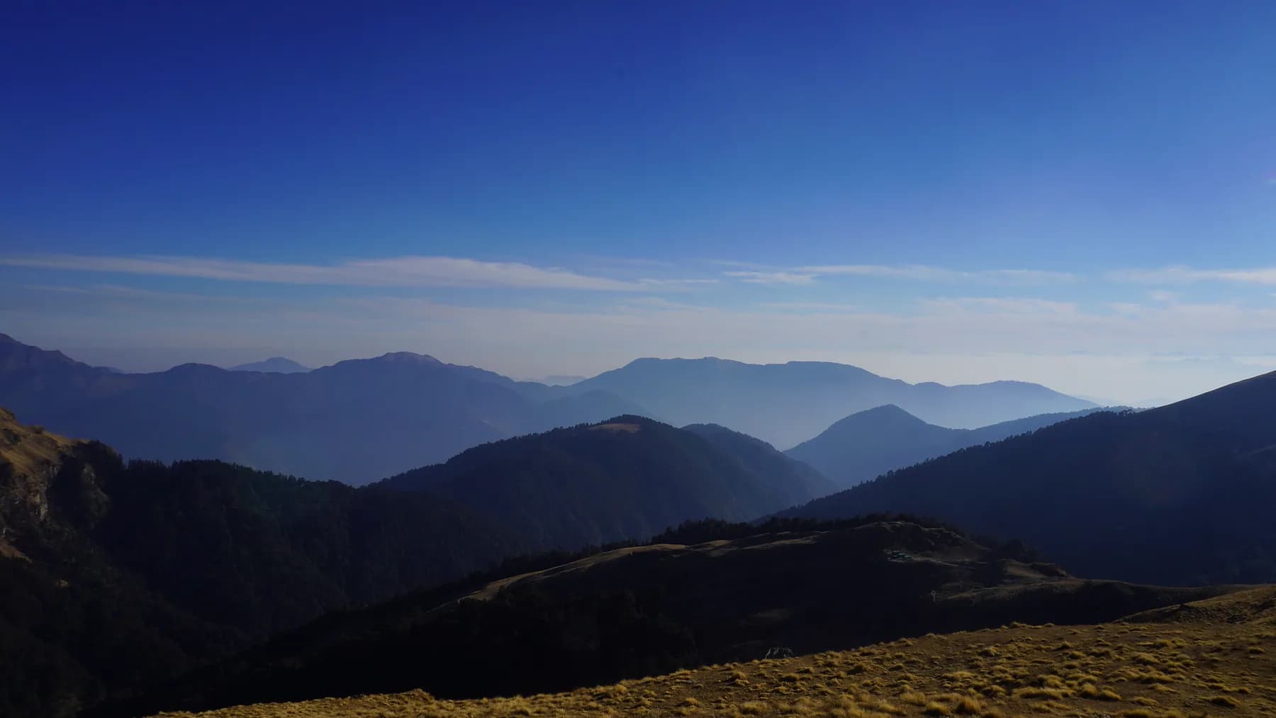 Layered blue mountain valleys seen from Ali Bugyal