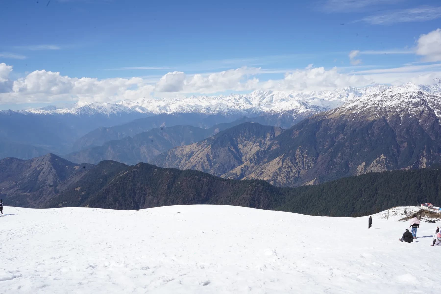 Wide snowfield below a continuous panorama of Himalayan peaks