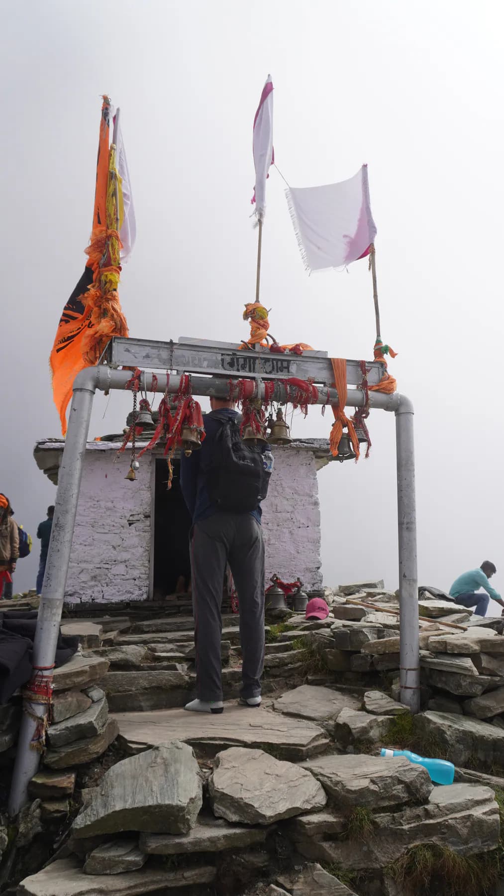 Trekker at the small stone shrine on Chandrashila summit