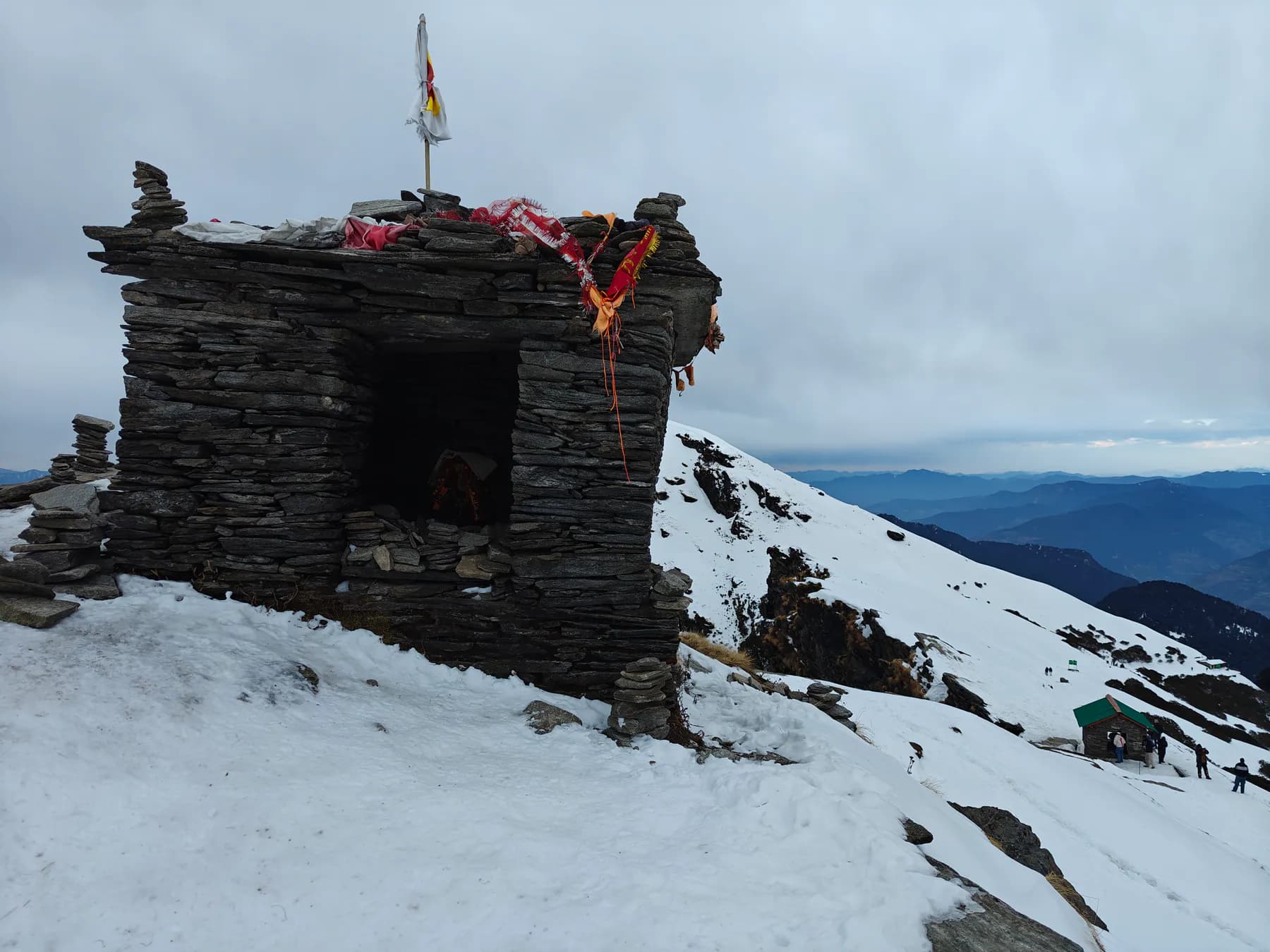Stone shrine surrounded by snow near the Chandrashila ridge