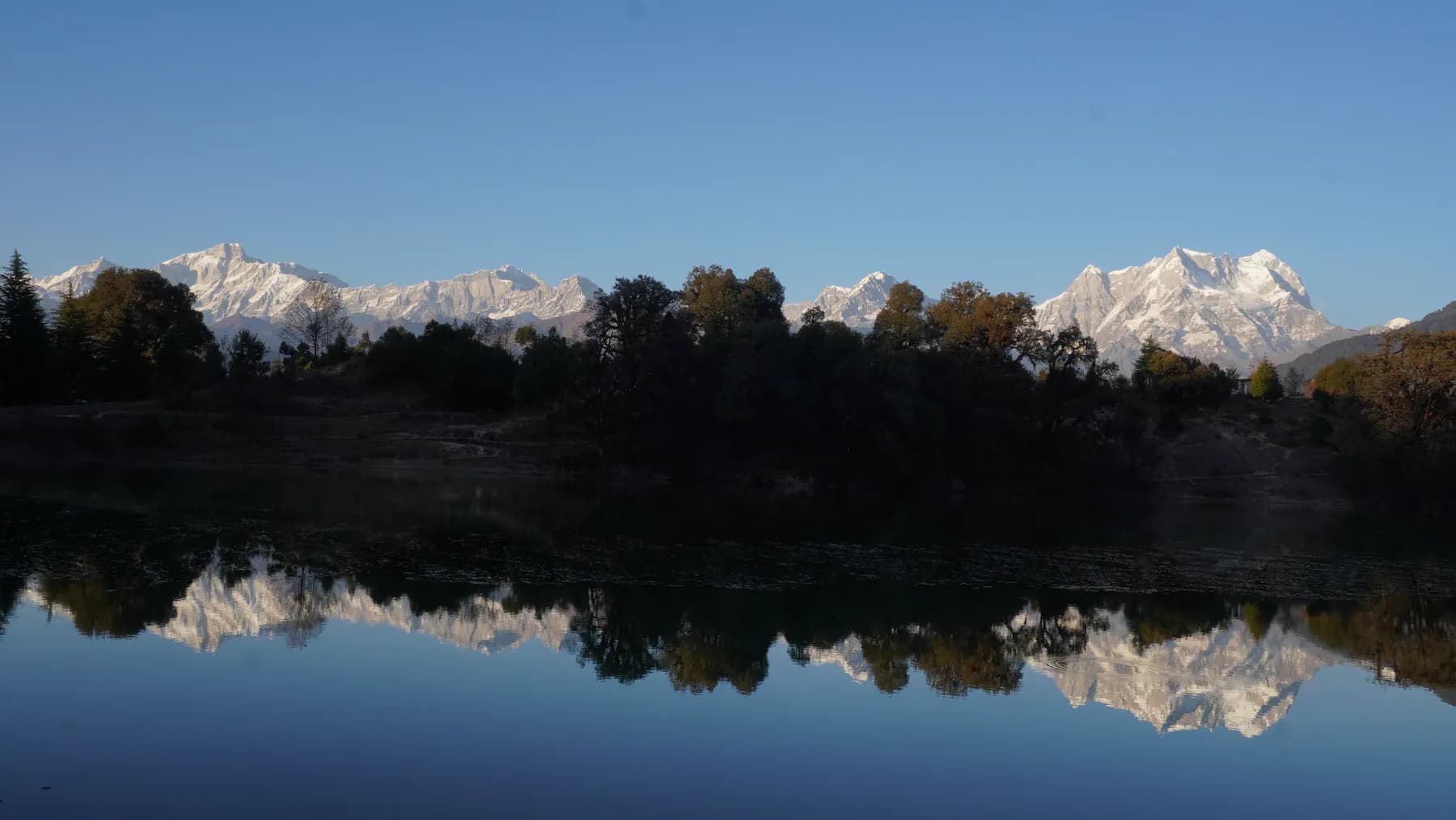 Snow-covered Garhwal Himalayan peaks reflected in the still water of Deoriatal