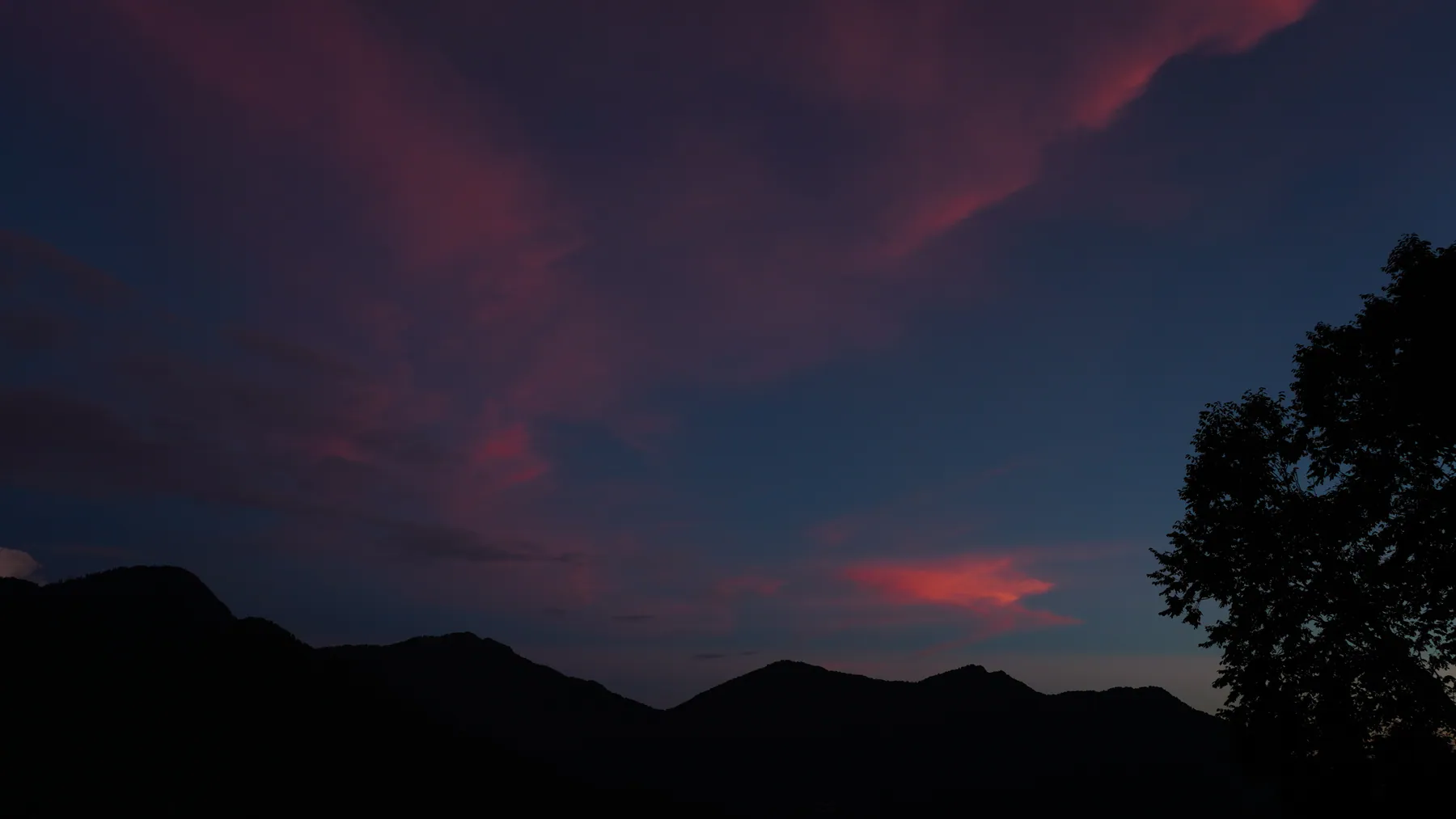 Crimson twilight clouds above the dark ridges near Sari Village