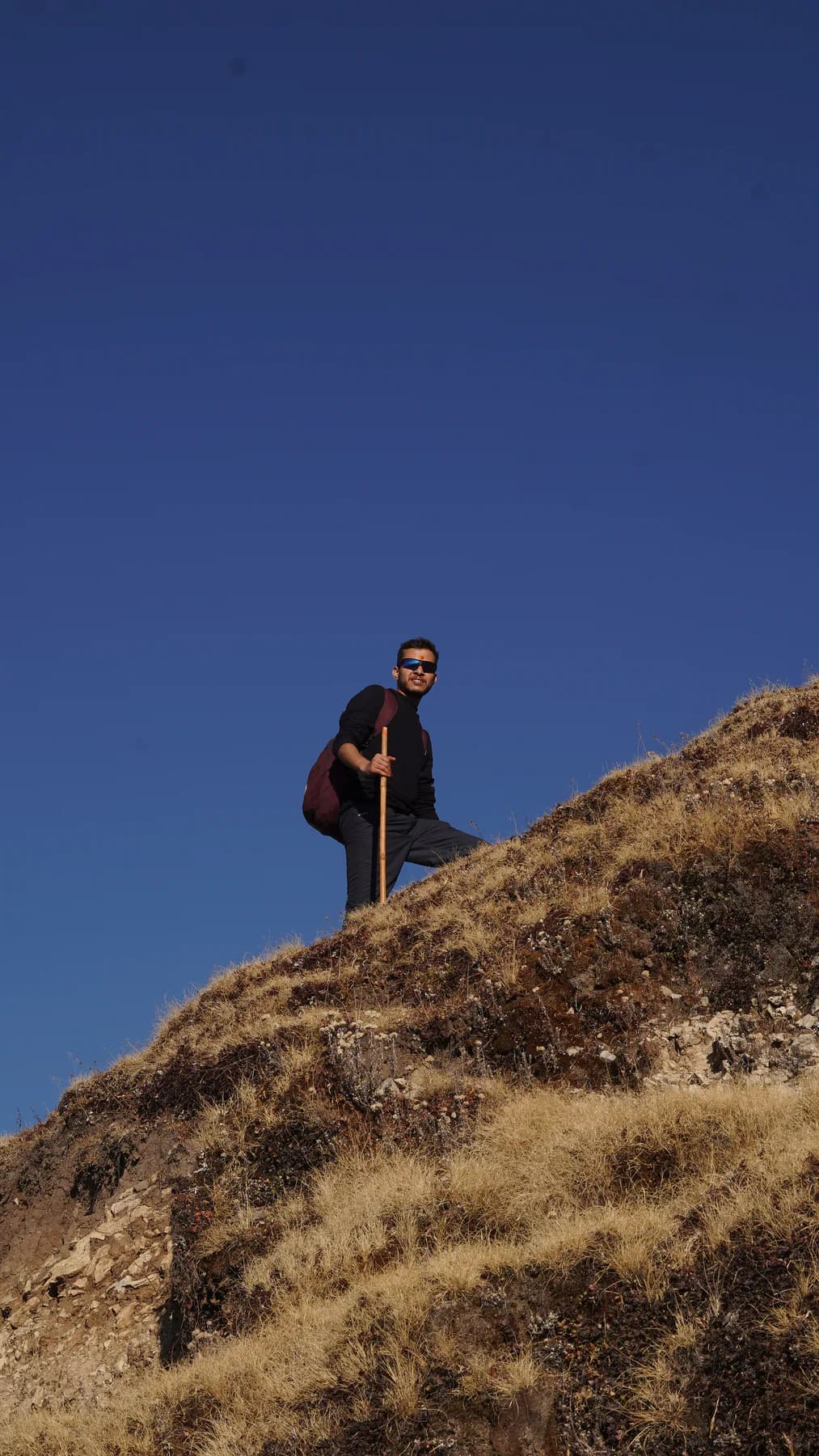 Trekker standing on a high ridge below Chandrashila