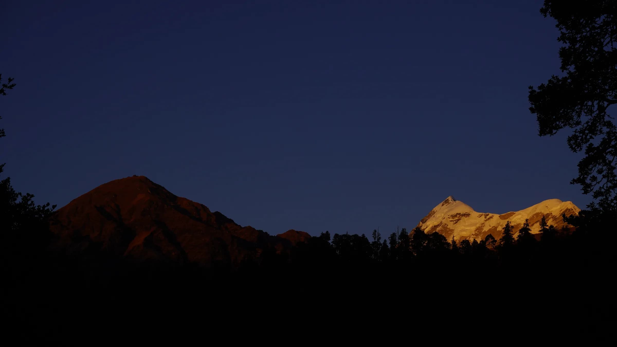 Snow-covered Himalayan peaks glowing in golden light near Ali Bedni Bugyal
