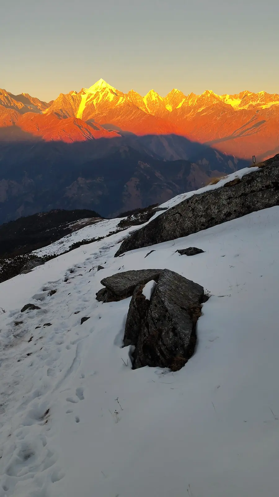 Panchachuli peaks glowing at sunrise above the snow trail